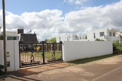 a white fence with a gate in front of a house at Villa Kayana in Flic-en-Flac