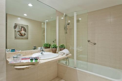 a bathroom with a sink and a glass shower at Hotel Luze El Toro in Berrioplano