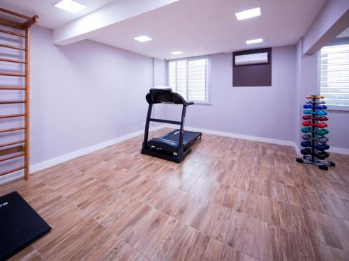 a gym with a treadmill in a room with wooden floors at Vila Business Hotel in Volta Redonda