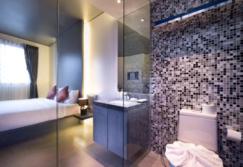 a bathroom with a bed and a shower and a toilet at Kamala Resotel, SHA Extra Plus in Kamala Beach
