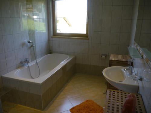 a bathroom with a tub and a sink at Ferienhaus Sam in Innsbruck