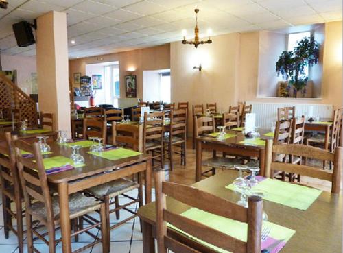 une salle à manger avec des tables et des chaises en bois dans l'établissement Hôtel Restaurant du Pont-Vieux, à Saint-Flour