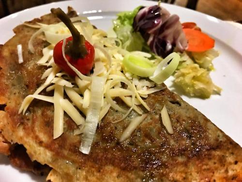 a white plate with a piece of food with cheese and vegetables at Hotel Bothe in Považská Bystrica