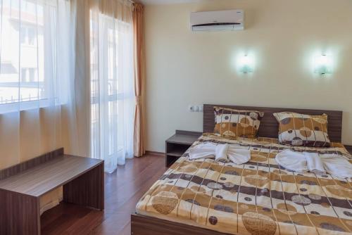 a bedroom with a large bed and a window at Hotel Ray in Sozopol