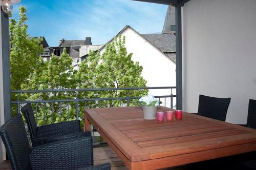 a wooden table and chairs on a balcony at Ferienhaus Cuxborn 7 in Zell an der Mosel