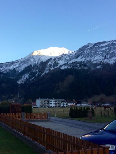 a snow covered mountain in the distance with a fence at Appartements Wacker in Bichlbach