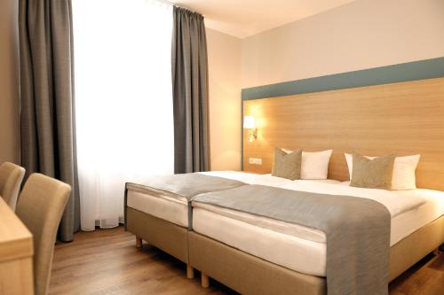a bedroom with a large bed in a hotel room at Hotel & Gasthaus DAS RÖHRL Straubing in Straubing