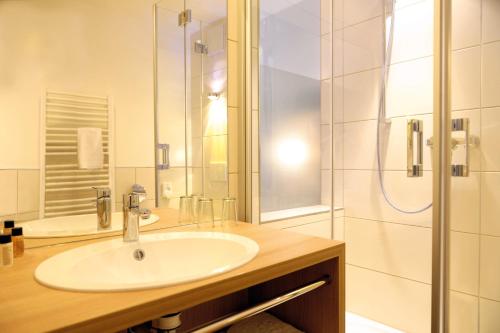 a bathroom with a sink and a shower at Hotel & Gasthaus DAS RÖHRL Straubing in Straubing
