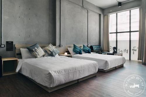 two beds in a large room with at Wuhoo House in Kaohsiung