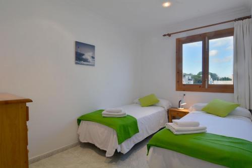 a bedroom with two beds and a window at Front Line Beach Apartment in Son Serra in Son Serra de Marina