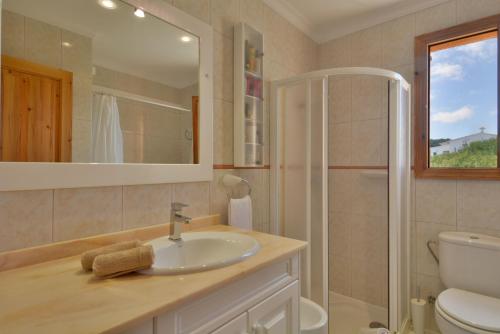 a bathroom with a sink and a toilet and a mirror at Front Line Beach Apartment in Son Serra in Son Serra de Marina