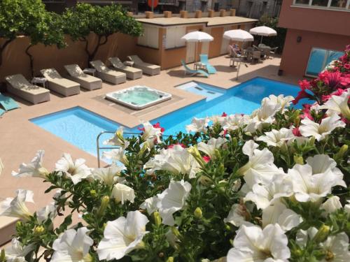 a pool with white flowers in front of a building at Hotel Monte Rosa in Chiavari