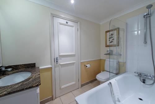 a bathroom with a tub and a sink and a toilet at The Colonnade in London
