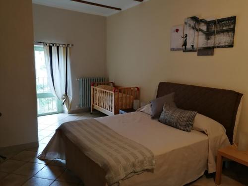 1 dormitorio con cama y cuna en Locanda Montecarlo, en Lesegno