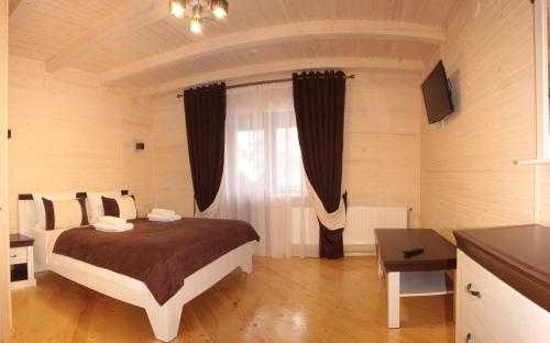 a bedroom with a bed and a large window at Family Hotel Kaskad in Bukovel
