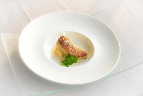a white plate with a piece of food on it at Logis Hôtel et Restaurant du Dauphin in Sées