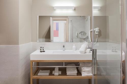 y baño con lavabo y espejo. en VOI Arenella Resort en Arenella