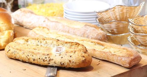 three loaves of bread sitting on a cutting board at Trinite Hotel in La Trinité-sur-Mer