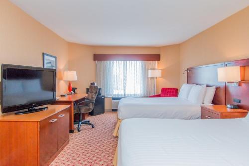 a hotel room with two beds and a flat screen tv at Doubletree By Hilton Battle Creek in Battle Creek
