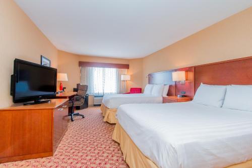 a hotel room with two beds and a flat screen tv at Doubletree By Hilton Battle Creek in Battle Creek