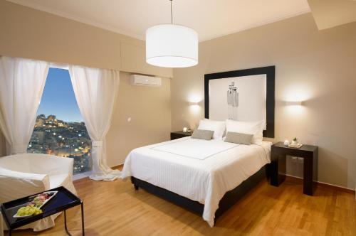 Un dormitorio con una gran cama blanca y una ventana en ALTIUS LODGE by K&K en Atenas
