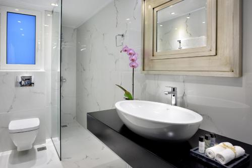 een badkamer met een wastafel, een toilet en een spiegel bij ALTIUS LODGE by K&K in Athene