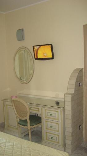 a dressing table with a mirror and a chair at Hotel Ginevra in Poggiomarino