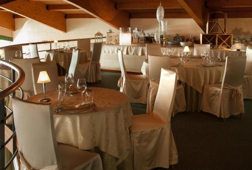 a dining room with tables and chairs and tablesearcher at Hotel Leonardo da Vinci in Erba