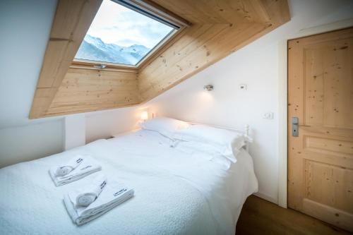 une chambre avec un lit blanc avec une fenêtre dans l'établissement Rupicapra apartment - Chamonix All Year, à Chamonix-Mont-Blanc