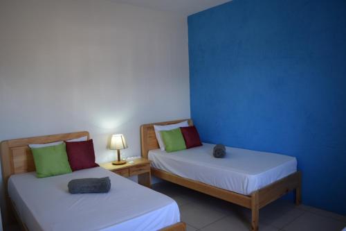 Habitación con 2 camas y pared azul en Ocean Mist, en Flic en Flac