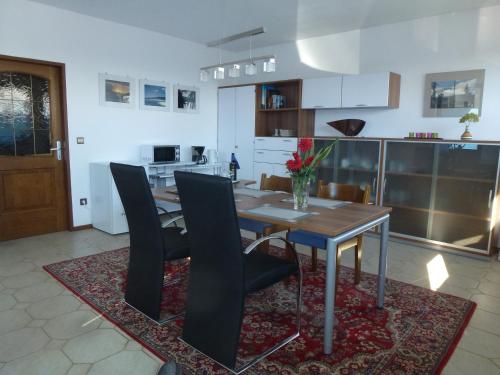 kuchnia z drewnianym stołem i czarnymi krzesłami w obiekcie Appartment Cerny w mieście Eisenstadt