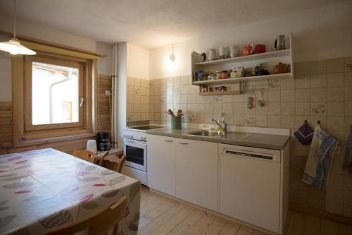 a kitchen with a sink and a table and a window at Chasa Anguel in Samnaun