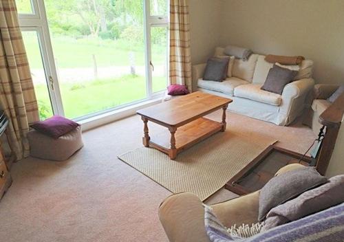 a living room with a couch and a coffee table at Ardno Cottage by Loch Fyne in Cairndow