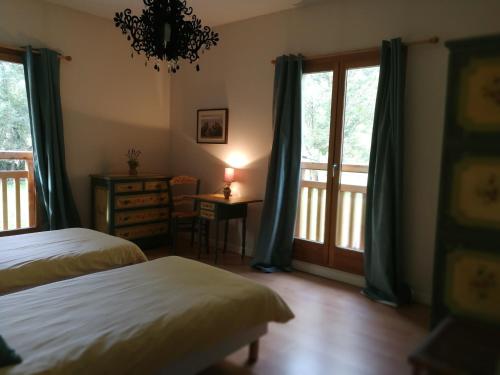 1 Schlafzimmer mit 2 Betten und einem Balkon in der Unterkunft Maison Josephine in Le Bourg-dʼOisans