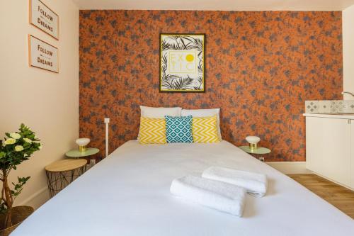 - une chambre avec un lit blanc et du papier peint orange dans l'établissement WS Champs Elysées - Ponthieu, à Paris