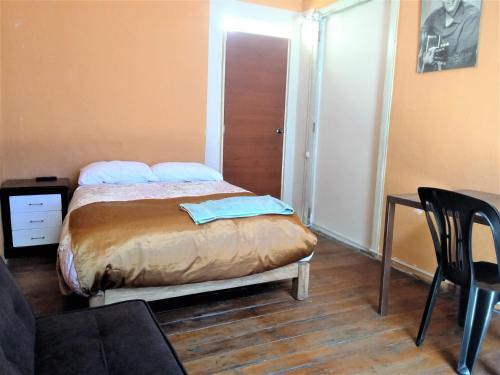 a bedroom with a bed with a chair and a table at Casona Moya in Arequipa