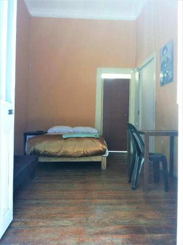 a bedroom with a bed and a table and a chair at Casona Moya in Arequipa