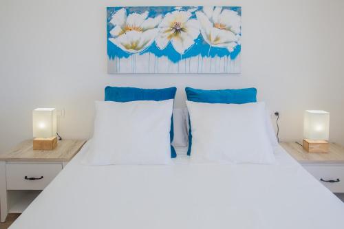 a bedroom with two white beds and two lights at Flower Beach Suite 25 in Playa Honda