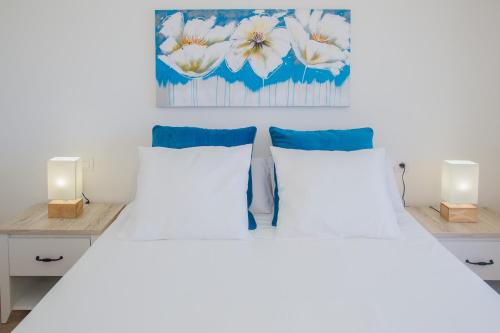 プラヤ・オンダにあるFlower Beach Suite 25のベッドルーム1室(白いベッド2台、照明2つ付)