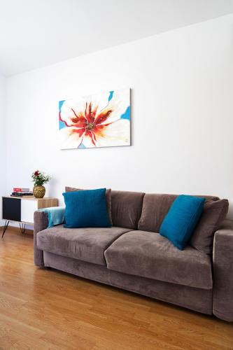 a brown couch in a living room with blue pillows at Casa Bella Pantheon in Rome