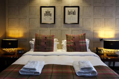 a bedroom with a large bed with two towels on it at Forrester Park Resort in Dunfermline