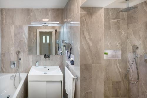 a bathroom with a white sink and a shower at Veleslavinova 4 - Old Town Apartment in Prague
