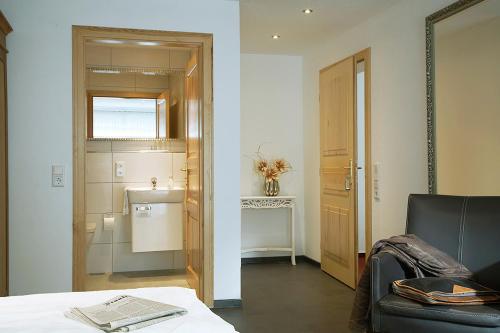 Zimmer mit einem Bett und einem Bad mit einem Waschbecken in der Unterkunft Hotel Restaurant Daute in Iserlohn