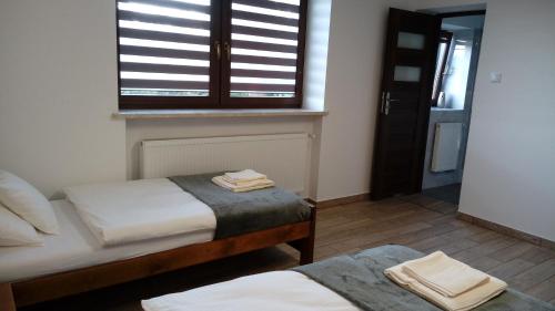 a bedroom with two beds and a window at Leo House in Gaj