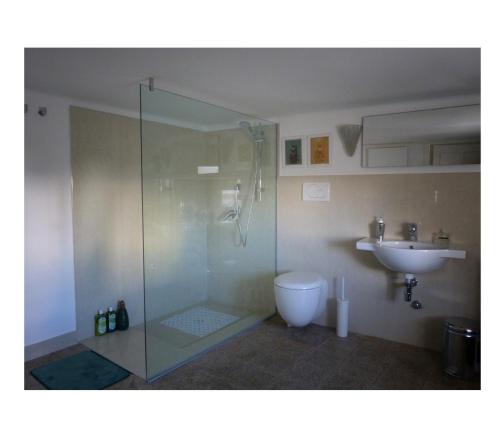 a bathroom with a glass shower and a sink at La Casa di Anna G. in Alberobello