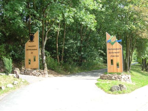 two signs on the side of a road with trees at Ferienwohnungen Finke in Frankenau