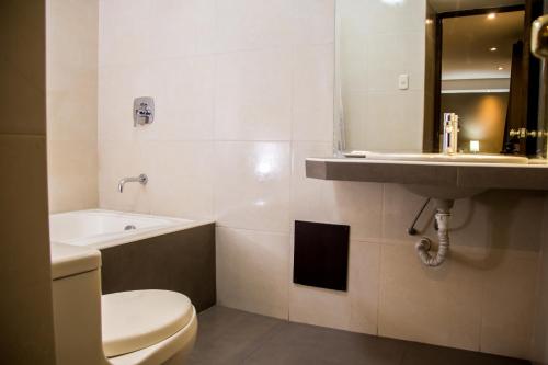 a bathroom with a toilet and a sink at Hotel Cajamarca in Cajamarca