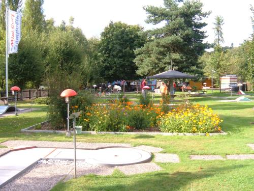 a park with a garden with flowers and an umbrella at Ferienwohnungen Finke in Frankenau