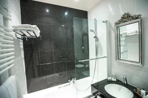 a bathroom with a glass shower and a sink at Boutique Hotel Die Swaene in Bruges