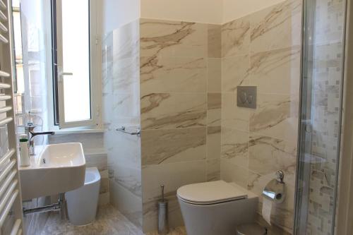 La salle de bains est pourvue de toilettes, d'un lavabo et d'une douche. dans l'établissement Termini Station apartment AI DUE CORTILI presso le mura aureliane, à Rome